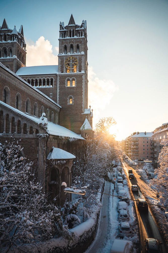 A serene snow-covered church in Munich, captured in beautiful photography, perfect for winter-themed wall decor and travel photography enthusiasts.